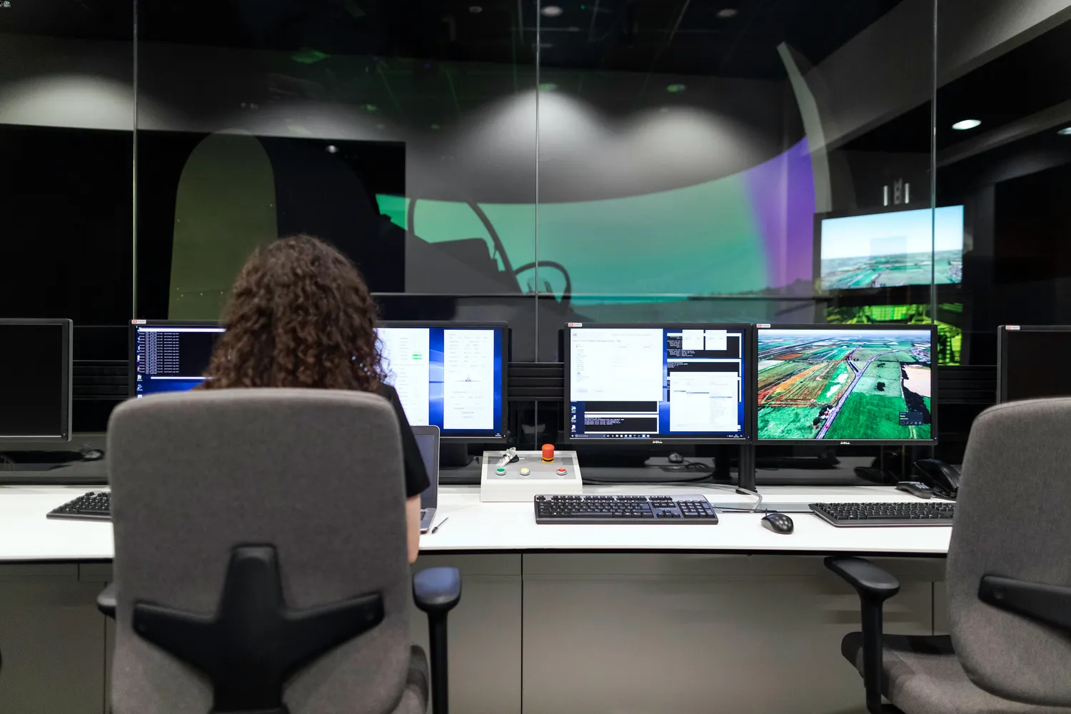 About 1 woman in a office with multiple screens